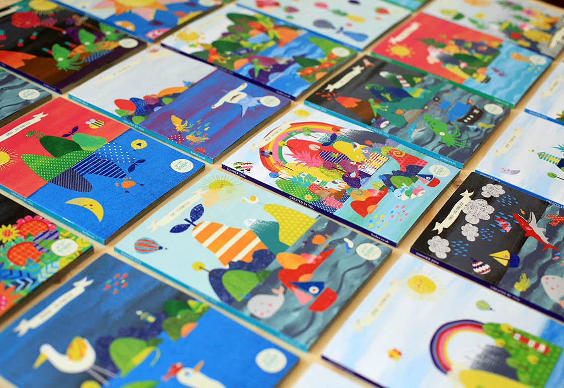 Lots of different cover designs laid out on a table