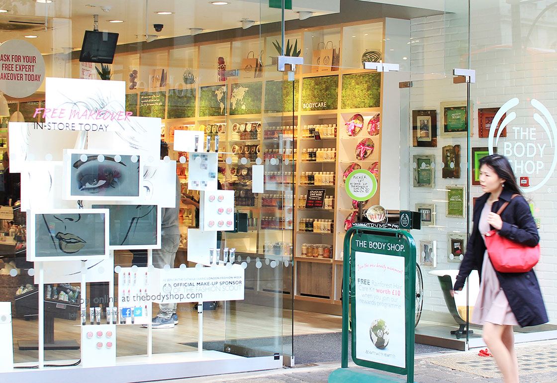 Someone walking past the shop window that has the screen installation in it