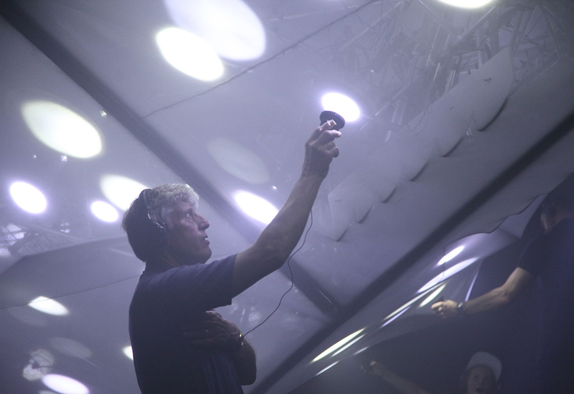 A dark room with people looking at lights in the shape of a plane