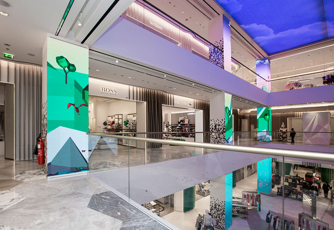 Photo of the store atrium with large screens on the vertical columns