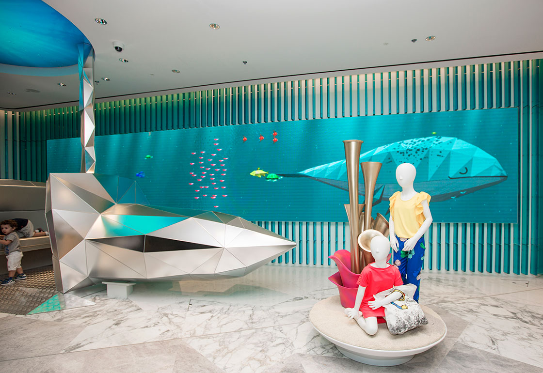 Photo of the store atrium with large screens on the vertical columns