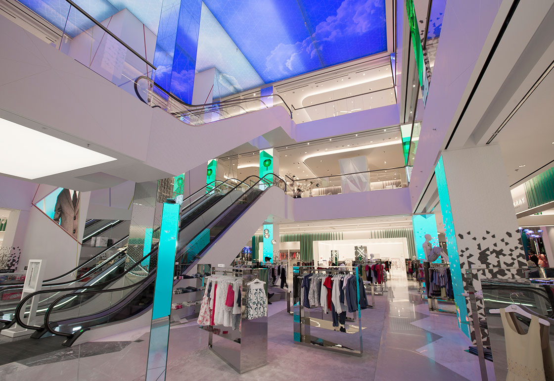 Photo of the store atrium with large screens on the vertical columns
