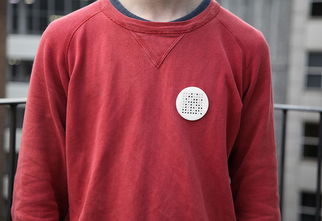Pollution badge pinned to a red jumper
